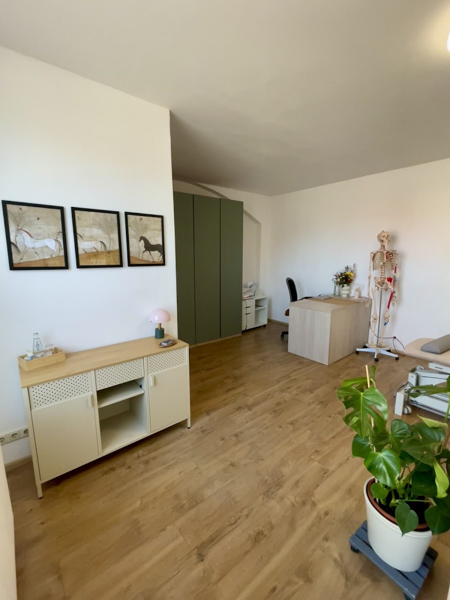 Behandlungsraum der Praxis mit Liege, Sideboard und Skelettmodell